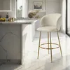 A modern kitchen with a marble island and a cream-colored bar stool with gold legs. Produktbild-Vorschau