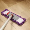 A mop with a purple chenille microfiber head is cleaning a wooden floor, leaving a clean path. Produktbild-Vorschau