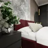 A close-up view of a bedroom with a bed, nightstand, and wallpaper. Podgląd zdjęcia produktu