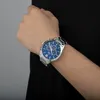 A person's wrist wearing a silver watch with a blue face. Produktbild-Vorschau