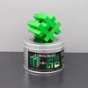 Grünes Hashtag Puzzle aus Metall steht dekorativ auf einer runden Metalldose mit Produktaufkleber. Produktbild-Vorschau