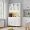 A white sideboard with glass doors in a kitchen or dining room setting. Náhled obrázku produktu