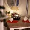 A dining table set for a festive occasion with a small fireplace and Christmas decorations. Náhľad obrázku produktu