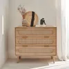 A wooden dresser with rattan drawer fronts is displayed in a well-lit room. Anteprima dell’immagine prodotto