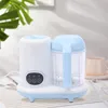 A baby food maker sits on a table with a plant in the background. Produktbild-Vorschau