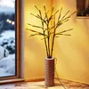 Decorative LED branches in a vase, placed indoors near a window with a snowy view. Produktbild-Vorschau