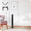 A modern black tower fan is placed on a wooden floor in a child's room, next to a pink armchair and a white crib. Four framed animal prints are hung on the white wall behind the fan and chair. Podgląd zdjęcia produktu