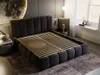A modern bedroom with a large upholstered bed. Produktbild-Vorschau