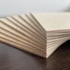 A stack of thin wooden boards, likely plywood, fanned out on a dark wooden surface. Produktbild-Vorschau