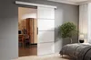A sliding door is shown partially open, revealing a home office setup on the left and a bedroom on the right. Náhled obrázku produktu
