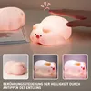 A collage of images showing a cute pig-shaped LED night light, with a hand touching it in the top image to demonstrate touch control. Podgląd zdjęcia produktu
