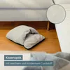 A gray foot massager is placed on a wooden floor next to a sofa. A close-up of the fabric texture is shown in a circular inset. Anteprima dell’immagine prodotto