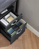 A close-up view of an open filing cabinet with two drawers, showing files and office supplies. Produktbild-Vorschau
