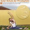 A mother and daughter are doing yoga on a mat in a garden, with a yellow PVC fence in the background. Náhled obrázku produktu