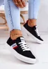 A person wearing black Lee Cooper sneakers and blue jeans. Náhľad obrázku produktu