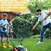 A father and son are in a backyard, with the son operating a lawnmower and the father using a garden aerator. Produktbild-Vorschau