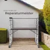 A mobile scaffolding unit is set up in an outdoor residential setting, with a house and garden in the background. Náhled obrázku produktu