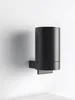 A black soap dispenser mounted on a white wall. Voir les images du produit