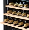 Close-up of wine bottles stored on wooden shelves inside a wine cooler. Produktbild-Vorschau