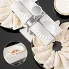 A white dumpling maker is shown with several finished and unfinished dumplings around it. Podgląd zdjęcia produktu