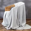 A gray blanket draped over a wicker chair. Náhled obrázku produktu
