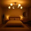 A bedroom scene with a bed, nightstands, a dresser, a mirror, and a chandelier. Náhľad obrázku produktu