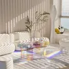 A modern living room with a white couch, a transparent acrylic coffee table, and a fluffy white rug. Sunlight streams through the blinds, casting striped shadows and a rainbow effect on the floor. Anteprima dell’immagine prodotto