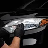 A person wearing a black glove is cleaning a car headlight. Anteprima dell’immagine prodotto