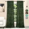A pair of green velvet curtains with a gold pattern, hanging in front of a window. A white sofa is visible on the left. Voir les images du produit