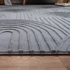 A close-up view of a grey rug with a geometric pattern, placed on a wooden floor. Anteprima dell’immagine prodotto