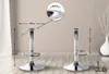 Two chrome bar stool bases are shown on a wooden floor against a neutral wall. Dimensions and a close-up detail are indicated with arrows and text. Podgląd zdjęcia produktu