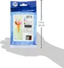 A hand is holding a package of Brother LC-3213 ink cartridges. Voir les images du produit