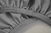 A close-up view of the elasticized hem of a dark gray fitted sheet. Produktbild-Vorschau