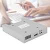 A close-up of a USB floppy disk drive emulator with a blurred background of someone using a laptop and phone. Náhľad obrázku produktu