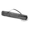 A gray camping chair is rolled up and placed in a carrying bag, lying diagonally on a white background. Produktbild-Vorschau