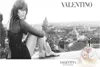 A woman sits on a ledge overlooking a city skyline, with a perfume bottle in the foreground. Voir les images du produit