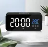 A digital alarm clock is displayed on a marble table with a plant in the background. Podgląd zdjęcia produktu