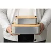 A person is holding two aluminum storage containers with bamboo lids. Anteprima dell’immagine prodotto
