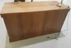 A wooden desk with a lamp on top and a power cord plugged in. Produktbild-Vorschau