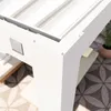 Close-up of the corner of a white pergola structure with a metal logo plate. Náhled obrázku produktu
