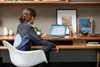 A woman is working on a laptop at a desk. Voir les images du produit