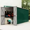 An open green metal shed with tools and storage inside, situated on a paved patio next to a building. Náhľad obrázku produktu
