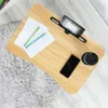 A wooden lap desk with a tablet, phone, papers, and a mug on it, placed on a fluffy rug next to a wooden floor. Produktbild-Vorschau