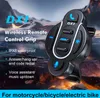 A close-up of a black motorcycle handlebar remote control with blue accents, set against a blurred background of mountains and fire. Produktbild-Vorschau
