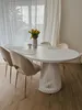 A dining table with chairs in a bright room with sheer curtains. Produktbild-Vorschau