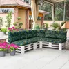 An outdoor patio setting with a sectional sofa made from white wooden pallets and green and yellow patterned cushions. Náhled obrázku produktu