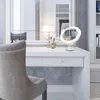 A makeup mirror with LED lighting on a white vanity table. Produktbild-Vorschau