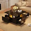 A modern coffee table with multiple drawers is placed in a living room setting, next to a sofa and near a fireplace. Náhľad obrázku produktu