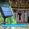 A split image showing a solar panel on the left and decorative lights on a fence on the right, with water droplets on both sides. Produktbild-Vorschau