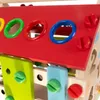 A close-up view of a colorful wooden toy house with various shaped holes and screws. Náhľad obrázku produktu